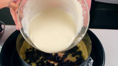 Kadın elleri kurabiye hamuruna krema doldurup evde yaban mersinli turta pişiriyor. Malzeme tarifi aşçılığı. Ev yapımı yemek fırını. Tatlı hazırlıyorum..