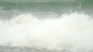 Powerful ocean waves crashing on pebble shore in stormy weather. Rolling and breaking against rocky coastline, showcasing natural dynamic marine energy. Huge foamy waves in sea storm.