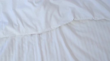 Kadınların parmakları yatakta beyaz çarşaflara bakar, yalnız uyur. Sağlıklı uyku rahatlığı, tembel sabah konsepti. Tatil, otel konseptinde dinlenme. Pedikür ve pembe tırnaklı kızlar.