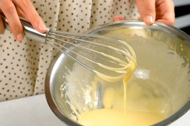 Kadın ev yapımı mayonez sosisi pişiriyor metal kasede malzemeler çırpıyor, elleri yakın plan. Salata için yemek sosu, et yemekleri. Farklı yemekler için giyinmek. Mutfak, mutfak konsepti.