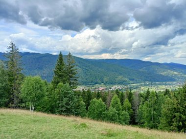 Gökyüzünün eşsiz bir manzarası Ukrayna Karpatlarının sayısız mavi sırtları üzerinde çeşitli şekil ve renklerle kaplıydı..