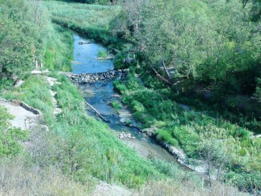 Tepenin tepesinden bozkır nehri üzerinden geçen yapay taşın manzarası Nizhnya Khorytsia.