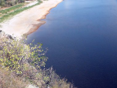Dinyeper 'ın mavi yüzeyindeki kayanın tepesinden kumlu bankalarla çevrili manzara yağmursuz yaz nedeniyle kesinlikle büyümüş..