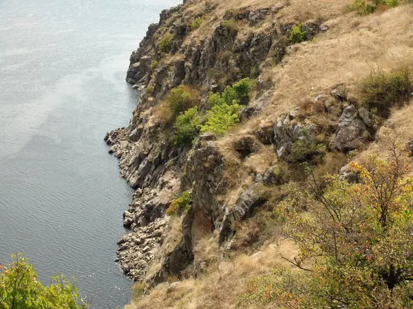 Stock image A view from above of the sharp-topped vertical coastal rocks, which are gently touched by the Dnieper water, reflecting the sun's rays.