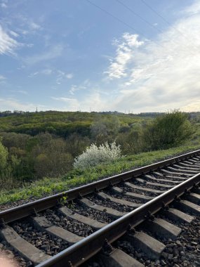 Gün batımından aydınlanan Ukrayna bozkırları boyunca uzanan tren yolu boyunca bir yürüyüş..