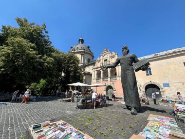 Lviv şehrindeki ilk yazıcı Ivan Fedorov 'a ait anıt, Lviv bölgesindeki Devlet Arşivleri binasının arka planına karşı..