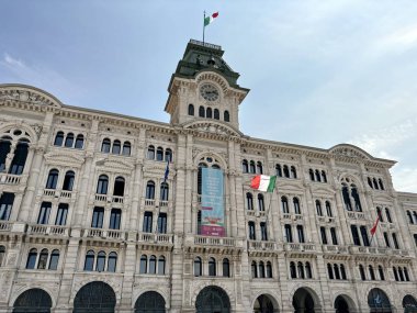 Trieste Belediye Binası 'nın antik binasının ihtişamının ve mimari benzersizliğinin altında güneşli ve bulutsuz bir gökyüzünün arka planına karşı bir manzara..