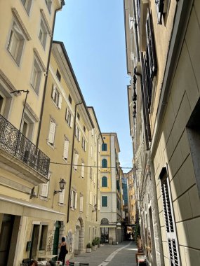 İtalyan şehrinin eski bölümünün dar sokakları boyunca uzun binaların gölgesinde, turistik yollardan uzakta bir yürüyüş..