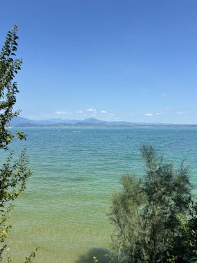 Hardy Gölü 'nün masmavi su yüzeyi ufuktaki uzak mavi tepelerle çevrili güneşli mavi gökyüzüne karşı..
