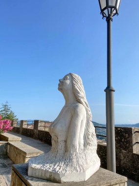 Kadınsı çekicilik ve güzellik, San Marino 'nun üst terasındaki mavi güneşli gökyüzüne bakan bir deniz kızının heykelinde vücut bulmuştur..