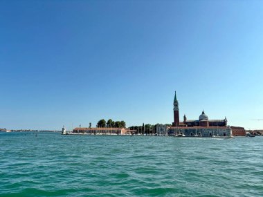 Büyük Kanal 'ın masmavi sularıyla çevrili Piazza di San Marco' nun benzersiz bir manzarası güneşli mavi Venedik gökyüzünün arka planında.