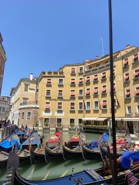 A view of decorated traditional Venetian gondolas moored near the parking lot waiting for the next ones to take a ride. clipart