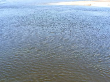 Dinyeper 'ın su yüzeyinin inanılmaz renkli arkaplanı su sütunu boyunca parlayan taş zeminin üzerinden esen hafif bir rüzgardan rahatsız olmuş..