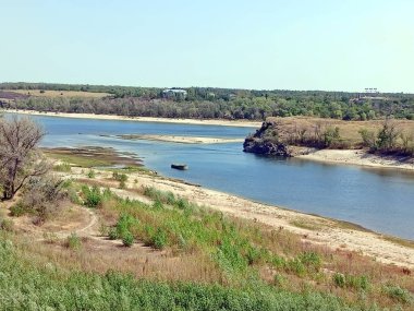 Şeffaf Dinyeper akıntısının panoraması ufuktaki sabah mavisi gökyüzünün arka planında Baida adasını yıkıyor..