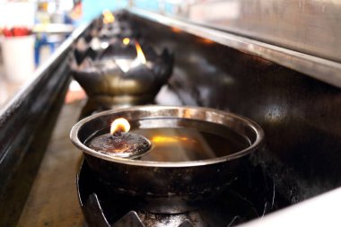 Eski usul paslanmaz lambalardan oluşan yuvarlak bir sıra yağ üzerinde yüzüyor, Tayland 'ın yuvarlak lambasında ateş parlıyor.