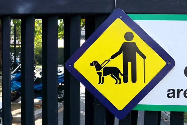 黒金属公園のドアに描かれた黄色の正方形のプレート上のブラインド男と犬のサイン — ストック写真