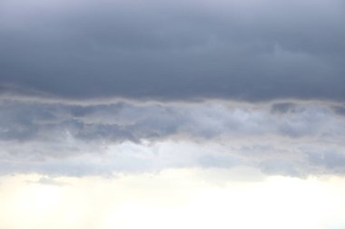 Beyaz ve gri bulutların tabaka tabaka altında ışık.