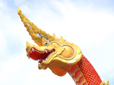 Kırmızı ve altın rengi çimento yılanın baş heykeli ve gökyüzü arka planında beyaz bulut, Tayland.