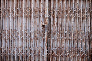 Boyanmış beyaz eski tarz katlanmış çelik kapı kapalı, kapının yüzeyi kahverengi..