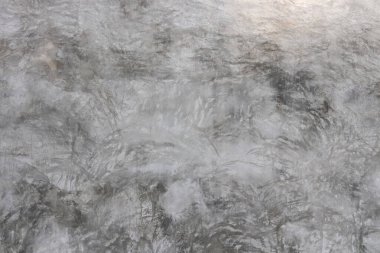 Pürüzsüz yüzey çimentosu üzerinde koyu ve soluk gri şerit, lekeli beton arka plan.