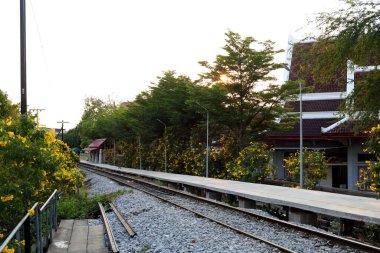 Demiryolunun yanında tren paravanı kaderi. Tayland 'da kırsal çevre günbatımı zamanı..