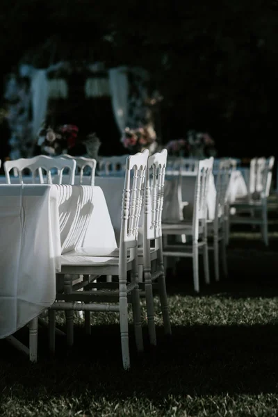 White chairs arranged in the garden during the wedding festively decorated tables outdoors