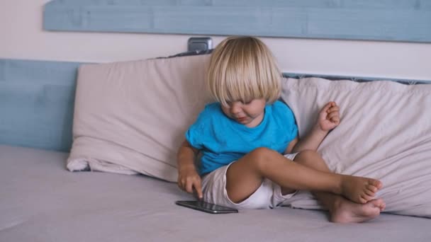 Bambino Piccolo Che Gioca Smartphone Sul Letto Filmati Alta Qualità — Video Stock