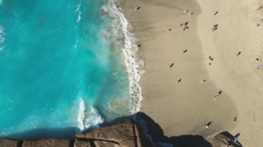 Turistlerin Tenerife adasındaki sahili ve dalgaları seyrettiği hava manzarası. Atlantik okyanuslu Playa del Duque. Yüksek kaliteli FullHD görüntüler