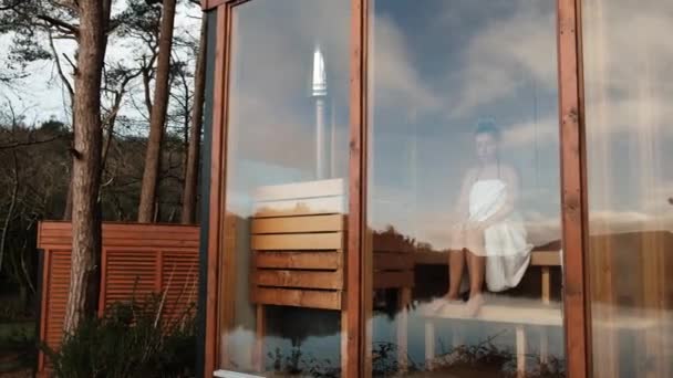 Young Woman Wrapped White Towel Sitting Sauna Panoramic Window High — Stockvideo