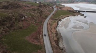 A drone follows a car driving down the road near Mizen Head. High quality 4k footage