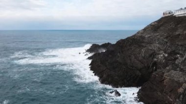 Aerial view of large waves crashing against the rocks at Mizen Head in county Cork Ireland. High quality 4k footage