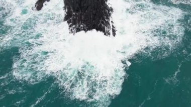 Aerial view of large waves crashing against the rocks at Mizen Head in county Cork Ireland. High quality 4k footage