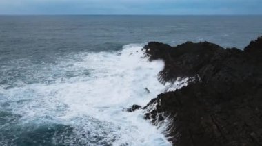 Aerial view of large waves crashing against the rocks at Mizen Head in county Cork Ireland. High quality 4k footage