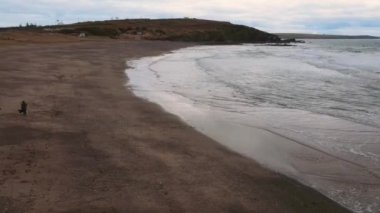 İHA bulutlu havada, İrlanda 'da okyanus sahillerinde uçar. Yüksek kalite 4k görüntü