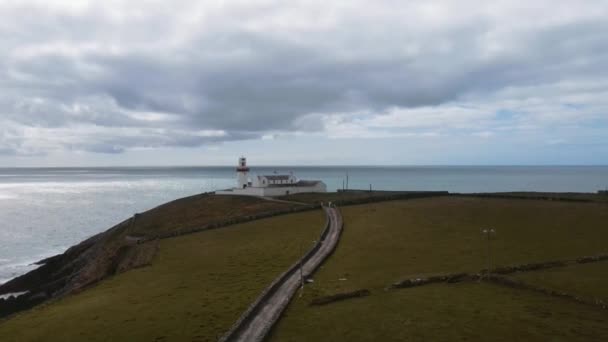 Dron Lecący Nad Białą Latarnią Morską Zielonej Skale Niedaleko Oceanu — Wideo stockowe