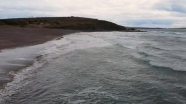 İHA bulutlu havada, İrlanda 'da okyanus sahillerinde uçar. Yüksek kalite 4k görüntü