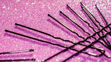 Beauty and fashion hairpins on sparkling pink surface