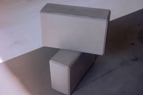 Two gray yoga blocks, foam yoga blocks on a mat, selective focus