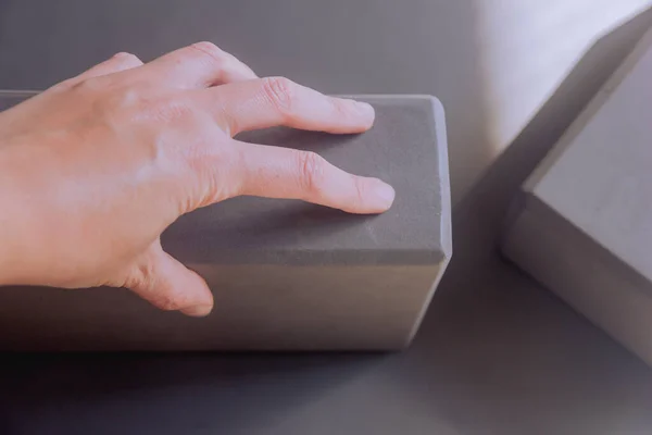 stock image Woman hand holding a yoga block, yoga workout with blocks on a mat, wellness concept, selective focus