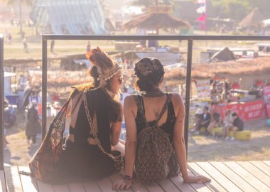 Pattaya, Tayland - 19 Aralık 2022: Harikulade Meyve Festivali 'nde eğlenen insanlar, Pattaya, Tayland' da gün batımını izleyen iki kız, seçici odaklanma, gürültü taneleri