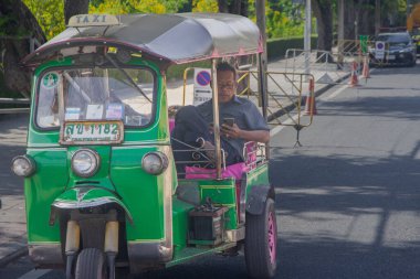 Bangkok, Tayland - Bangkok sokaklarında eski bir taksi şoförü, Tuk Tuk taksisinde oturan Asyalı bir adam