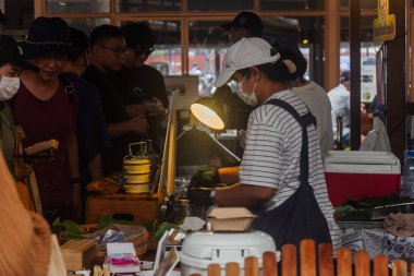 Chiang Mai, Tayland - 6 Ocak 2023: Jing Jai Market, bir hafta sonu sabah pazarı, Tayland 'ın kuzeyinde, Chiang Mai ilinde yer almaktadır. Asyalılar organik meyve ve sebze, kahve ve yiyecek satıyor