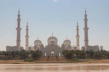 Gün batımında palmiye ağaçları olan Şeyh Zayed Büyük Camii manzarası. Şeyh Zayed Ulu Cami Abu Dabi, Birleşik Arap Emirlikleri. 
