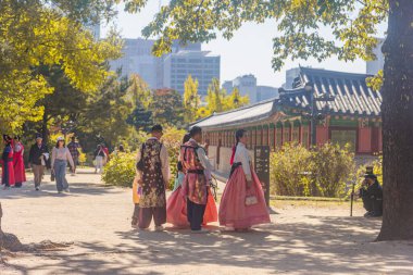 Seul, Güney Kore - 26 Ekim 2024: Gyeongbokgung Sarayı 'nda Hanbok kıyafetli ziyaretçiler. Her yaştan insan kültürel deneyimden zevk alır. Gyeongbokgung Sarayı 'nda yerli ve yabancı turistler.