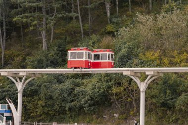 Busan, Güney Kore - 29 Ekim 2024 Busan Green Demiryolu 'nda yürüyüş yolu ve manzaralı renkli kapsül trenleri. Busan 'daki Haeundae Gökyüzü Kapsülü..