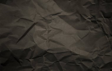 Görünür kıvrımları ve pürüzlü yüzeyi olan buruşuk siyah kağıt arka plan. Grunge, eko, vintage, ambalaj, tasarım arka planları ve sıkıntılı dokuma kavramları için mükemmel..
