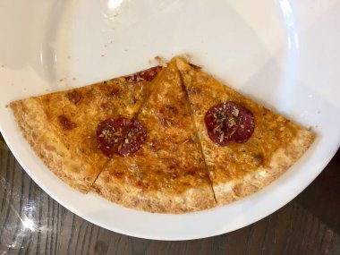 three slices of pizza on a white plate