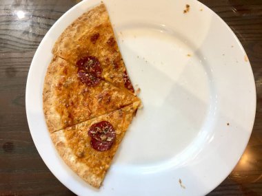 three slices of pizza on a white plate