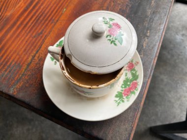 Bir fincan kahve, yarısı ahşap bir masanın üzerinde.