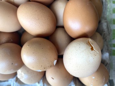 Yumurta yığını. Bazıları ahşap bir kutuda kırılır. Bazıları görünür.